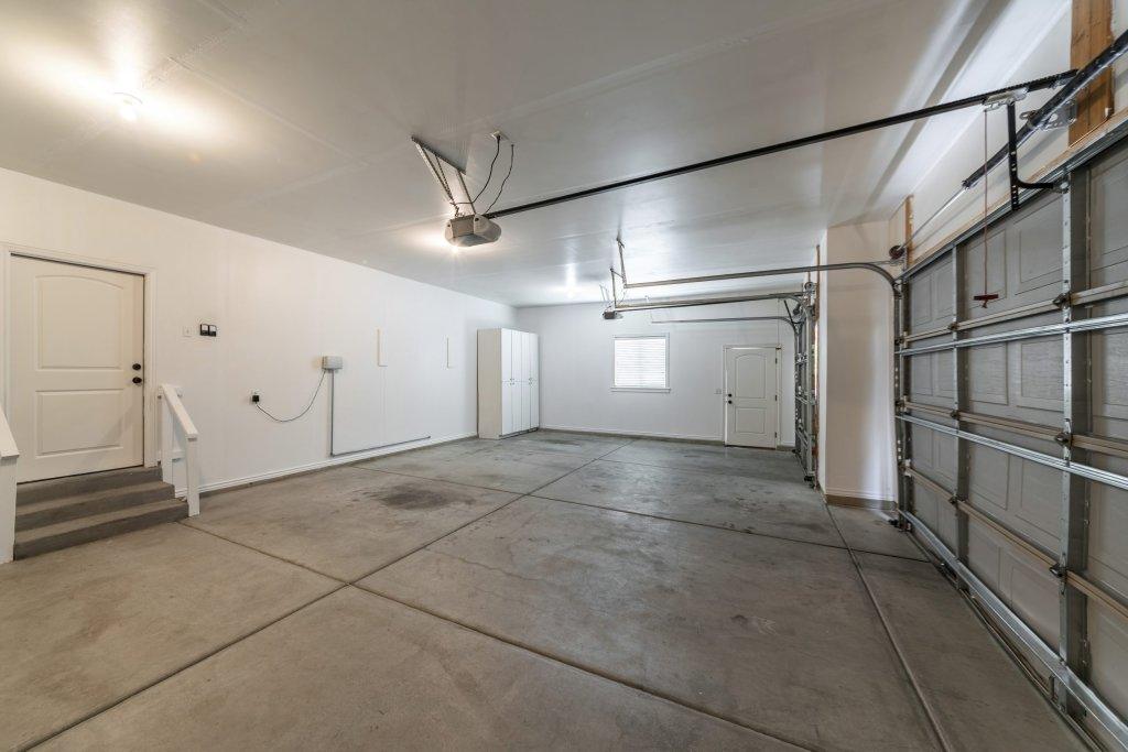 Interior of a garage with double automatic doors and concrete floor