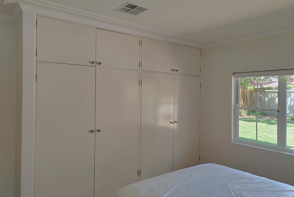 Bedroom with built-in wardrobes and window