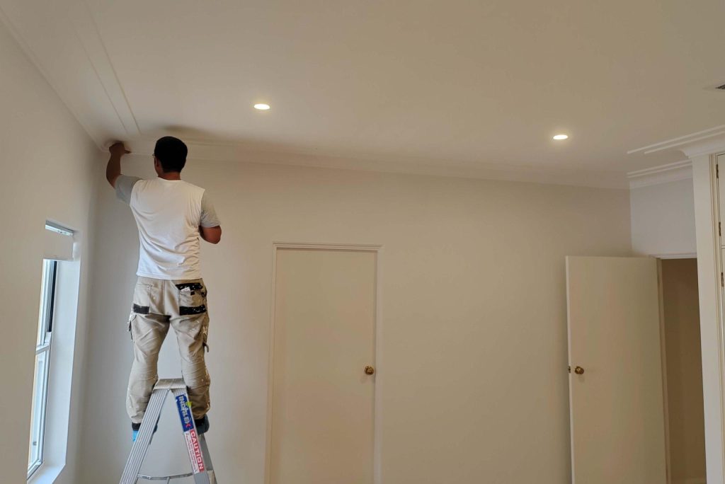 Painter working on ceiling in a residential room