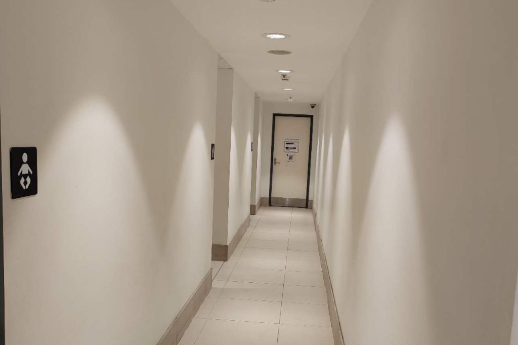 Interior of a narrow white corridor with tiled floor