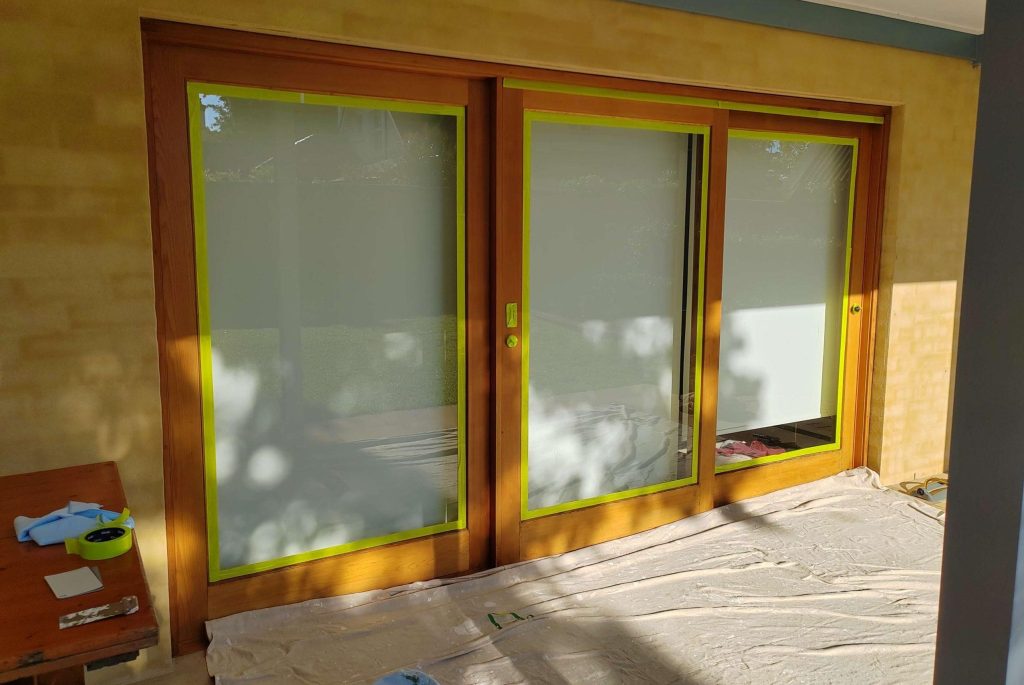 Sunlit patio doors with protective covering on the floor