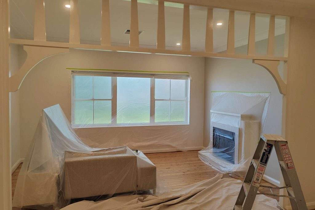Living room interior with furniture covered for painting
